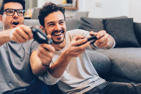 Zwei Männer haben Spaß beim Spielen mit der Spielekonsole.