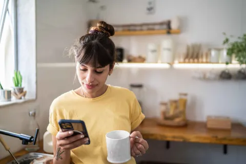 Eine Frau bekommt auf ihrem Handy eine digitale Zahlungserinnerung.