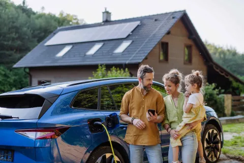 Familie lädt Elektroauto auf.