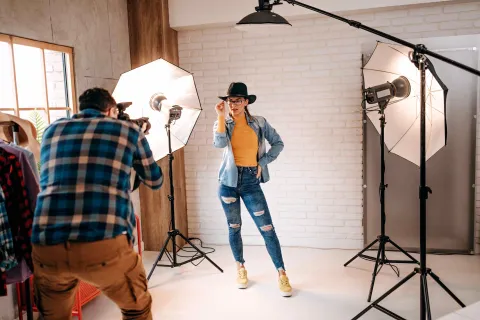 Ein Model wird beleuchtet und posiert vor einem Fotografen.