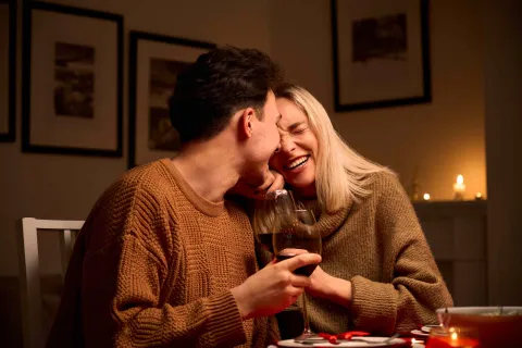 Ein Pärchen trinkt zuhause ein Glas Wein.