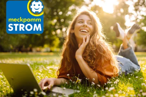 Eine junge Frau liegt auf einer Wiese. Oben links erscheint das meckpommSTROM-Logo.