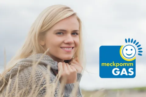 Eine junge Frau mit dickem Pullover am Strand. Unten rechts erscheint das meckpommGAS-Logo.