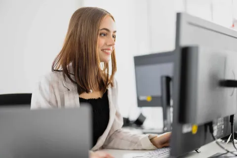 Junge Frau arbeitet am PC.