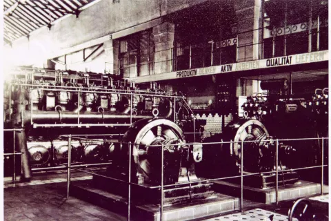 Schwarz-Weiß-Foto aus den 1950er Jahren eines Dieselmotors zur Stromerzeugung in der Maschinenhalle des E-Werk.