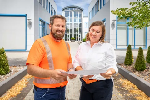 Eine Mitarbeiterin und ein Mitarbeiter der SWS unterhalten sich im Innenhof der SWS-Gebäude.