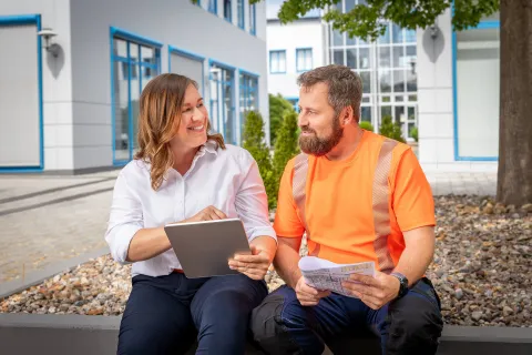 Eine Mitarbeiterin und ein Mitarbeiter der Stadtwerke Schwerin reden in guter Stimmung miteinander.