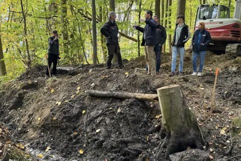 Personengruppe, die sich mitten im Moor im Gespräch befindet.