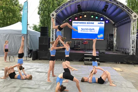 Acht Mädchen tanzen und turnen vor der Stadtwerke-Bühne.