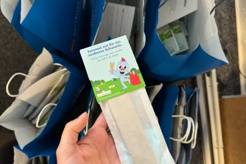Ein Müllsammelset in einer Frauenhand.