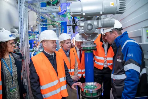 Bundeskanzler Scholz besichtigt gemeinsam mit Mitarbeitenden ein Geothermieheizwerk.