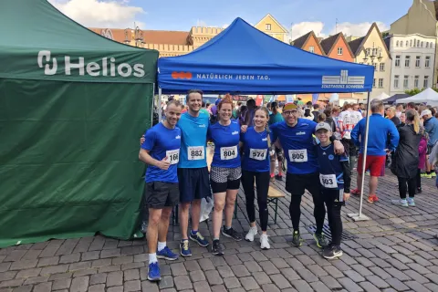 Eine Gruppe von Stadtwerke-Mitarbeitenden steht in Sportbekleidung bereit.