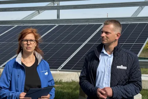 Eine Mitarbeiterin und ein Mitarbeiter der Stadtwerke Schwerin stehen vor einem PV-Modul.
