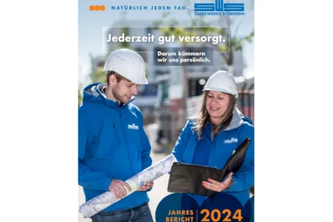 Mitarbeitende der Stadtwerke in Arbeistkleidung schauen auf einen Plan