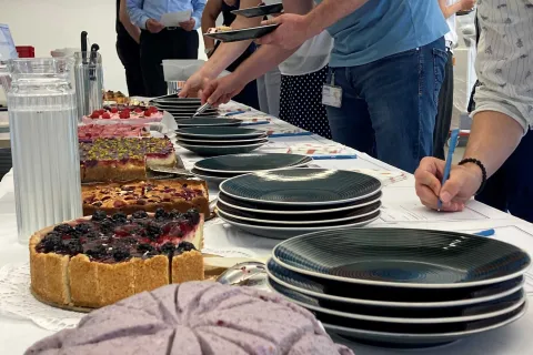Nahaufnahme Selbstbedienung am Kuchenbuffet mit Ausfüllen von beiliegen Bewertungszetteln. 