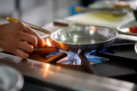 Person zündet Gasherd mit Streichholz an