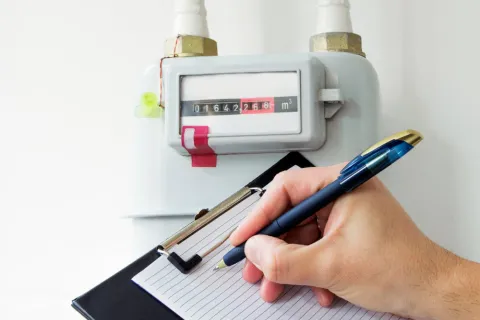 Person liest Gaszähler ab