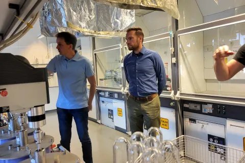 Zwei Männer stehen in einem Labor und schauen auf einen Versuch.