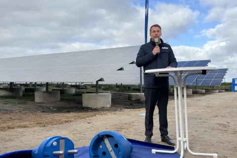 Stadtwerke Geschäftsführer Hanno Nispel hält eine Rede vor PV-Modulen