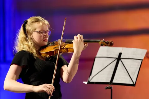 Junge Musikerin mit Violine und Notenständer