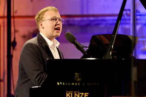 Junger Musiker beim Singen und Klavierspielen