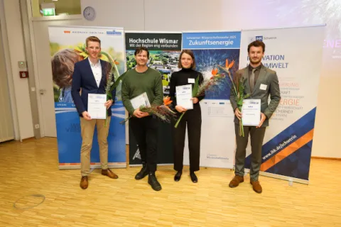 Vier Studierende mit Urkunden