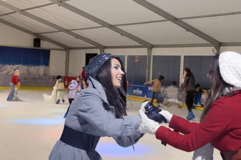 Zwei junge Frauen geben sich auf der Eisenbahn gegenseitig Halt und Lachen