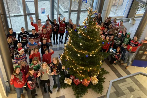 Mitarbeitende der Stadtwerke haben Weihnachtspullover an und winken