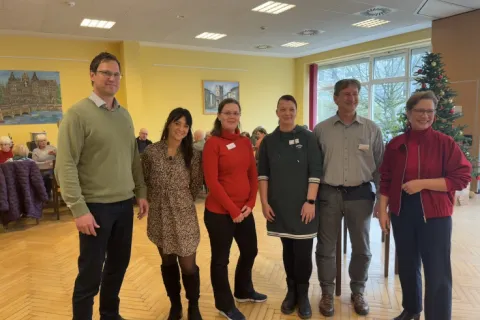 Eine Gruppe Menschen übergibt Spenden im Wärmeort