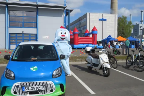 Maskottchen der Stadtwerke Schwerin steht im Elektrofuhrpark am Energiestandort Süd