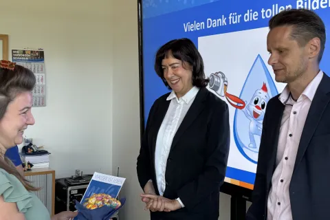 Die Geschäftsführung der WAG überreicht eine Urkunde an eine Preisträgerin