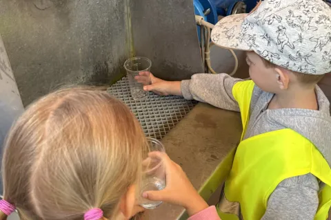 Zwei Kinder probieren Rohwasser