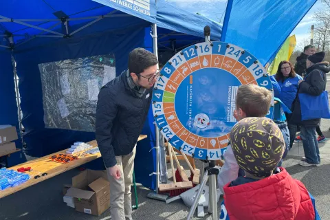 Ein Auszubildender der Stadtwerke Schwerin betreut Kinder am Glücksrad.