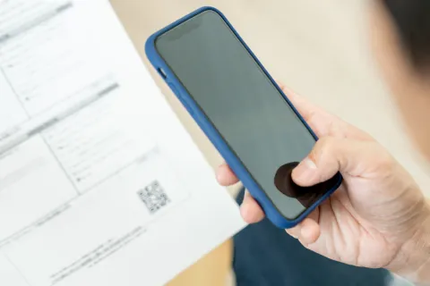 Eine Person scannt einen QR-Code mit einem Handy
