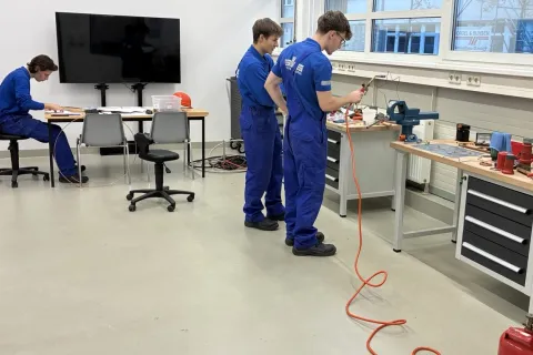 drei Auszubildende arbeiten in einer Lernwerkstatt