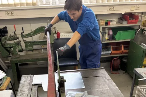 Ein gewerblicher Azubi arbeitet an einer Stanze