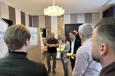 Mehrere Personen erarbeiten vor einer Metaplanwand Ideen