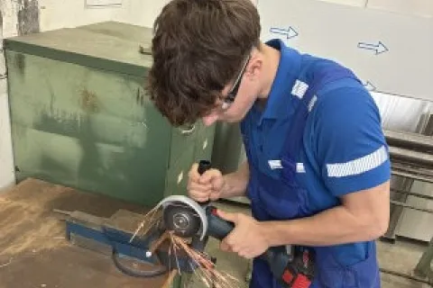 Ein junger Auszubildender arbeitet an einer Maschine