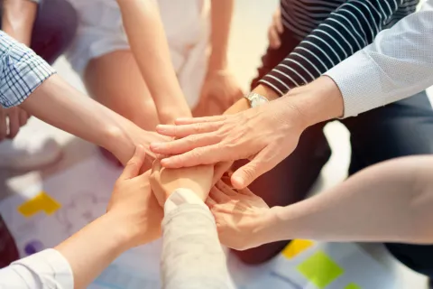 Viele Menschen legen die Hände aufeinander