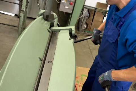 Ein junger steht an einer Maschine uns bereitet etwas vor.