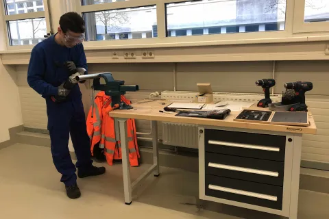 Auszubildender mit Arbeitsschutzbekleidung in der Lernwerkstatt der Stadtwerke Schwerin beim Arbeiten mit der Flex.
