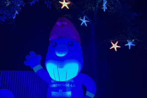 Beleuchteter Inflatable der aussieht wie ein typischer Gartenzwerg und ein T-Shirt mit dem Stadtwerkelogo und der Aufschrift Stromzwerg trägt.