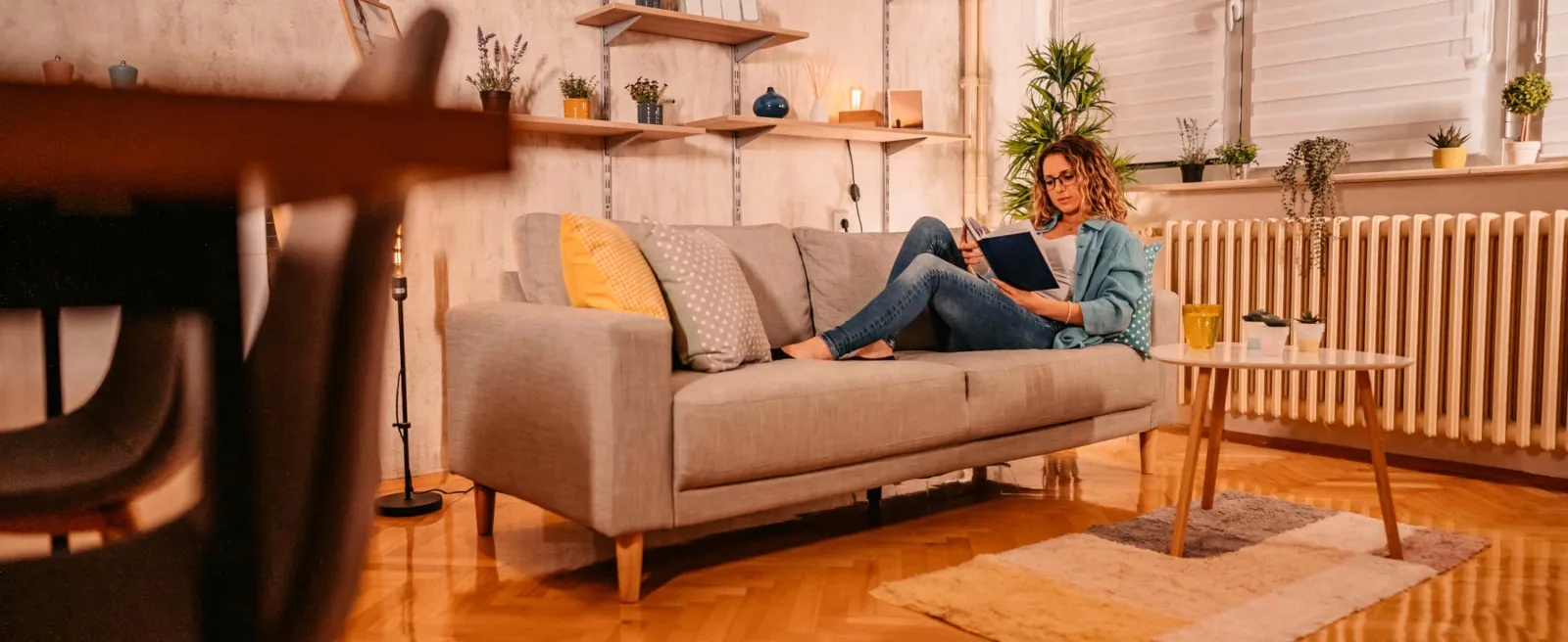 Eine Frau sitzt Zuhause auf ihrem Sofa.