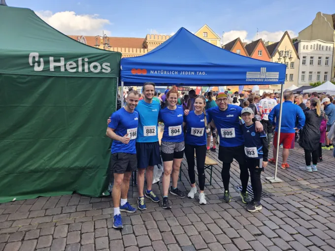 Gruppe von Stadtwerke Mitarbeitenden steht in Sportbekleidung bereit.