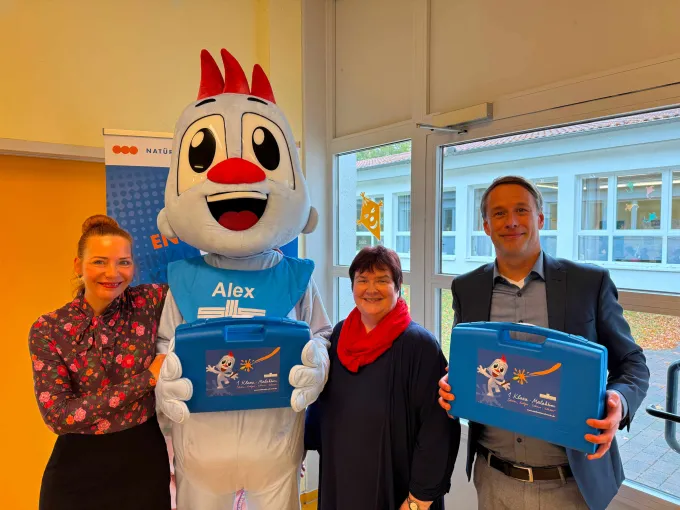 Drei Personen stehen mit dem Stadtwerkemaskottchen zusammen