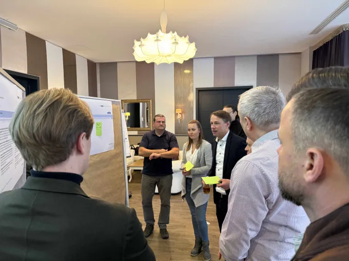 Mehrere Personen erarbeiten vor einer Metaplanwand Ideen