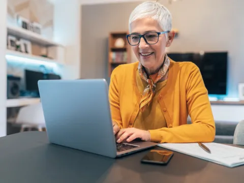 Eine Frau sitzt vor ihrem Laptop.