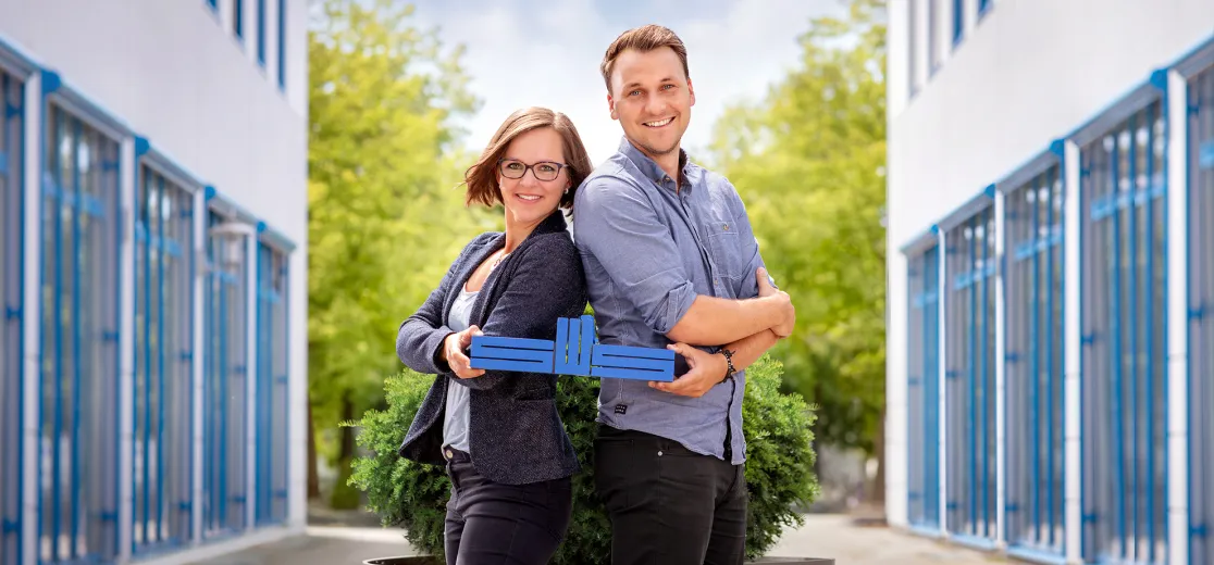 Zwei Mitarbeitende der Stadtwerke halten das Stadtwerke-Logo in der Hand.