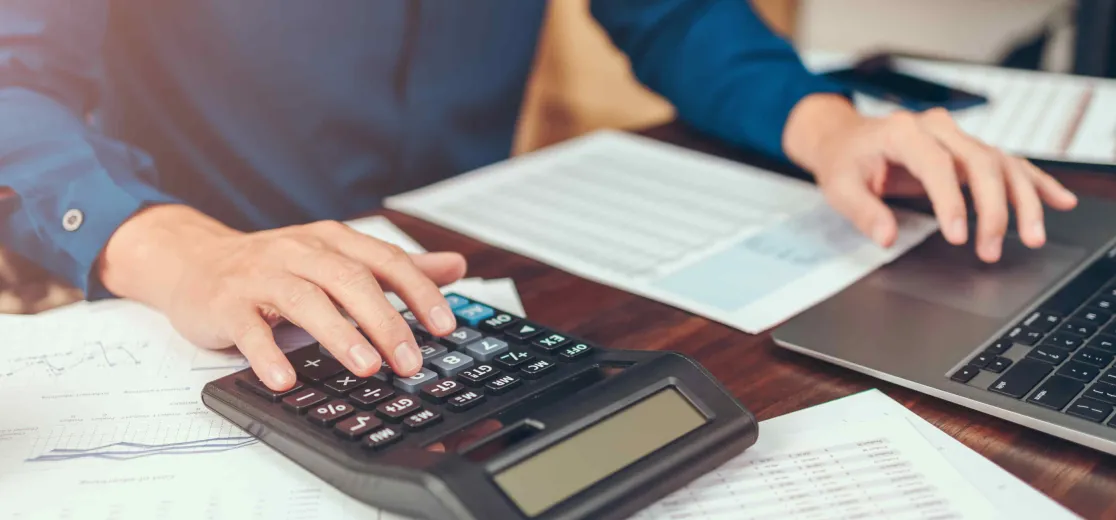 Ein Mann rechnet am Taschenrechner etwas aus.