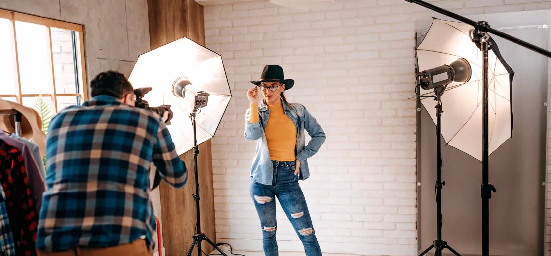 Ein Model wird beleuchtet und posiert vor einem Fotografen.
